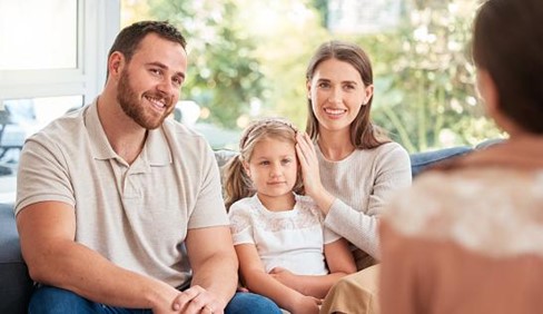 young parents with their little girl talking with a teacher